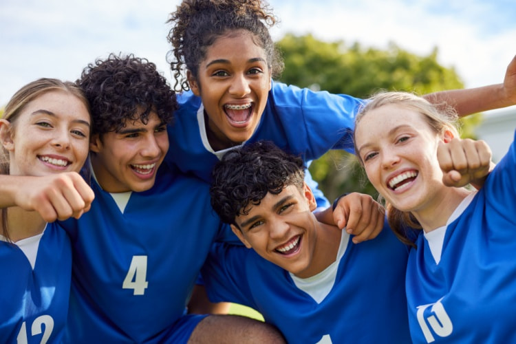 a group of young soccer players smile after a game