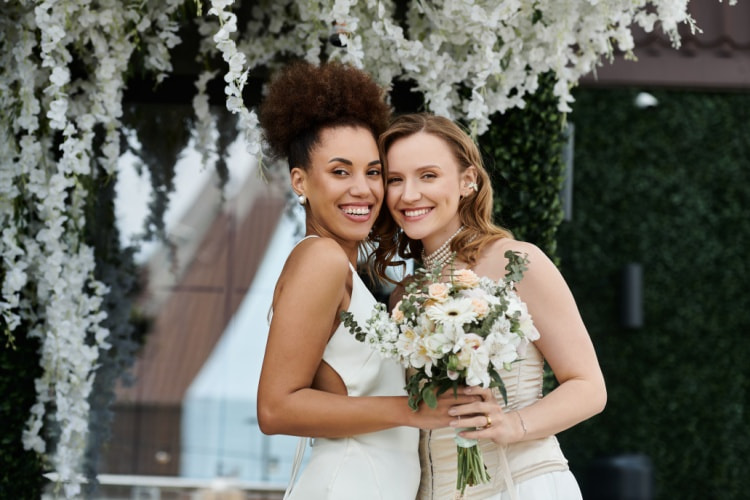 two brides pose for a picture before their ceremony